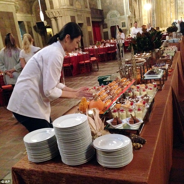 Feast: A worker puts finishing touches on the dessert table prior to the two-course dinner