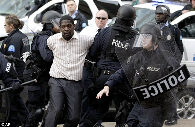 Detained and cuffed: Police arrest protest organizer Derrick Robinson as demonstrations against the failure to indict Officer Darren Wilson continued in St. Louis