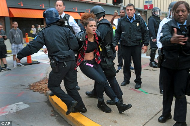 Dragged away: The female protester is removed from the scene by police offers before the St. Louis Rams and Oakland Raiders played on Sunday