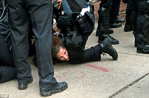 Flare-up: Police arrest a protester in St. Louis following an NFL football game between the St. Louis Rams and the Oakland Raiders on Sunday as protests continued following a grand jury's decision not to indict Darren Wilson