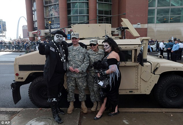 Some cheer: Oakland Raider fans Joe and Trisha Morrow, (right), take a photo with members of the Natural Guard on Sunday