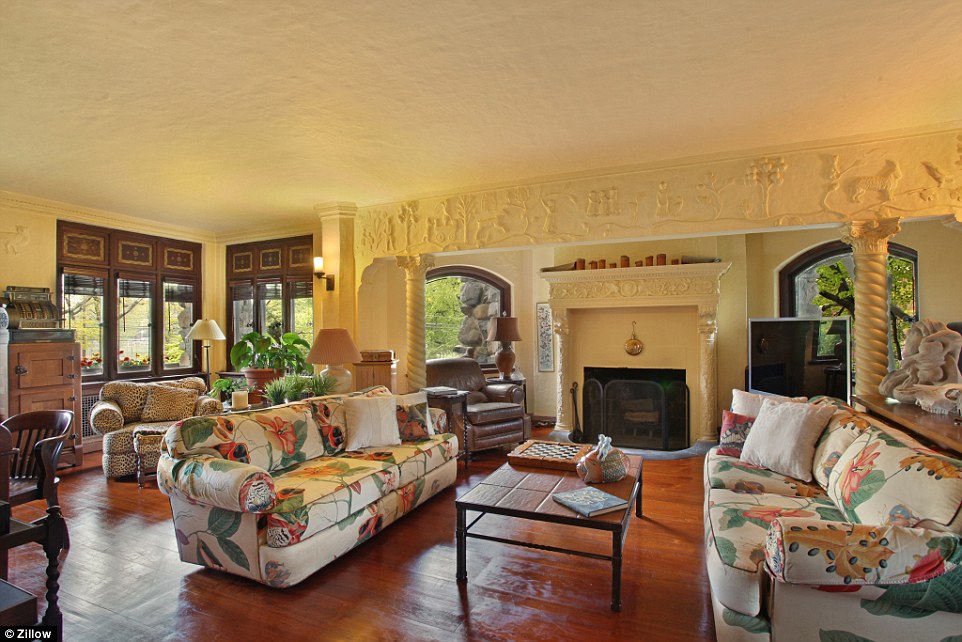 Whimsy: This siting room features a hodge-podge of different styles in both architecture and design: Solomonic columns and a bas relief around a fireplace, wooden windows and and overstuffed cheetah-printed armchair