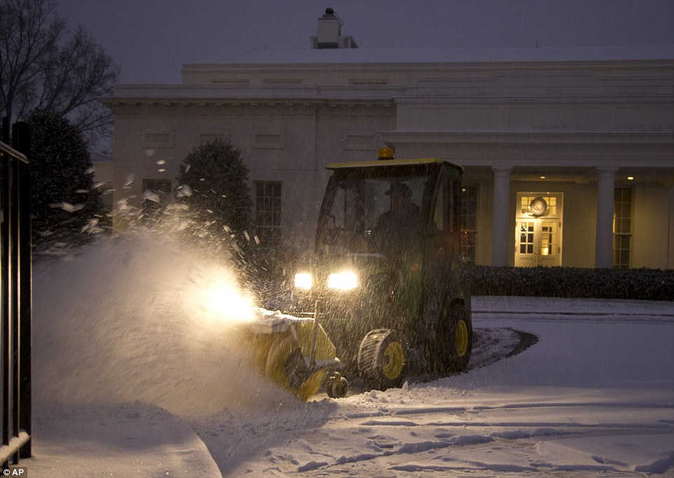 Very White House: A Unites States Park Service employee clears snow from in front of the West Wing of the White House in Washington on Tuesday