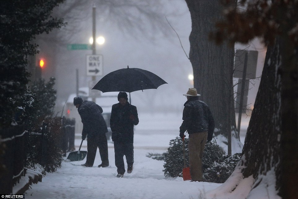 Slippery commute: A light snow blankets the sidewalks in the Capitol Hill neighborhood in Washington