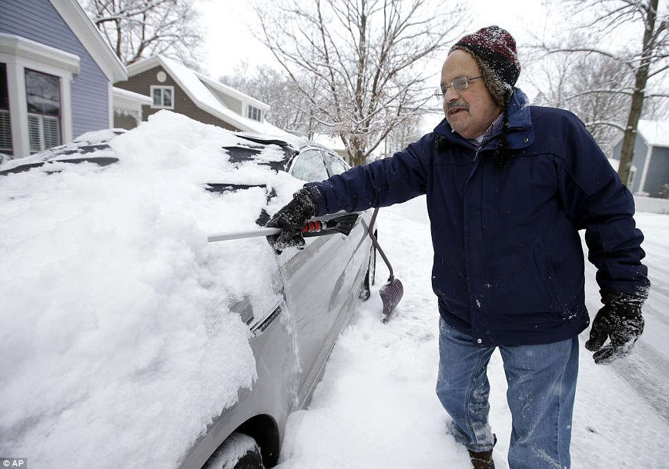 Brisk: Mike Mindel scrapes snow off his car Tuesday in Zionsville, Indiana