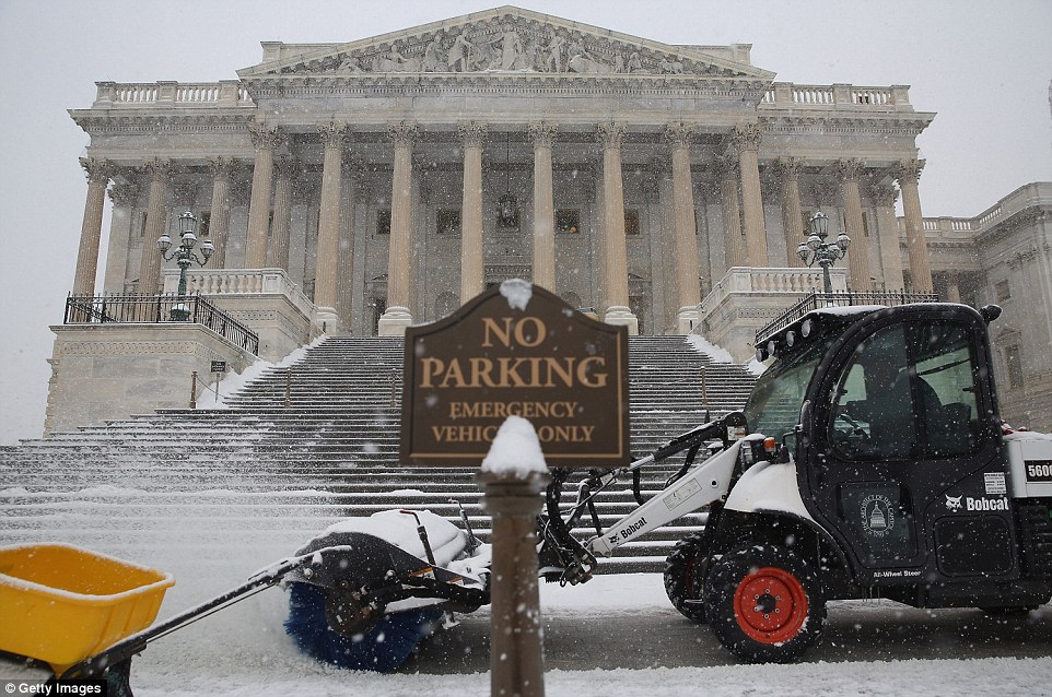 No parking: Clearing a path for the new Congress, employees of the Architect of the Capitol use tractors to remove snow from in front of the U.S. House of Representatives as more snow continues to fall