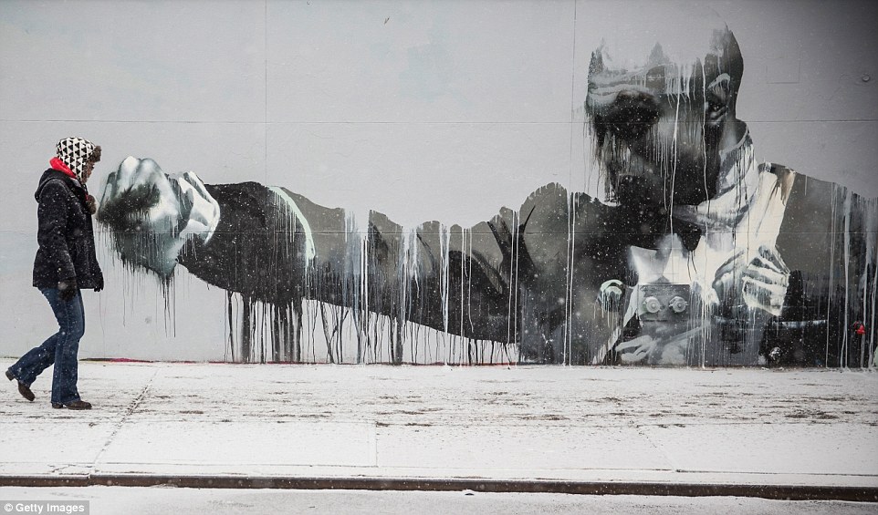 One-two punch: A woman walks down a snowy sidewalk on January 6, 2015 in New York City as the area was hit by its first major snowstorm of the winter season