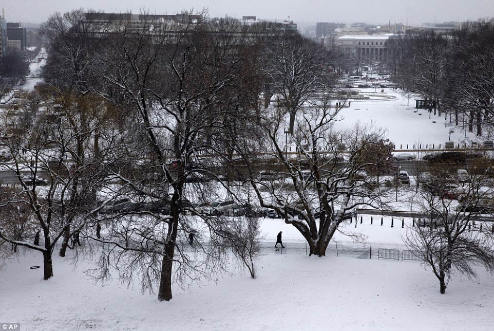 Snowy start: People walk toward the Capitol in Washington, Tuesday as snow falls on the start of the 114th Congress in Washington