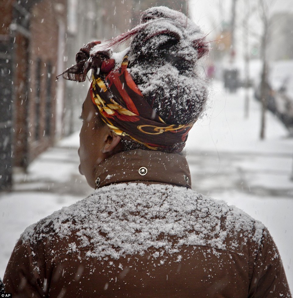 First of the year: A Bronx, New York pedestrian is dusted in snow Tuesday
