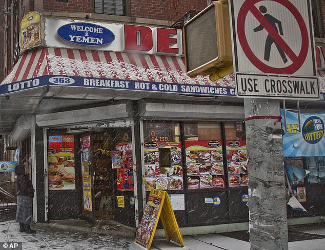 A woman approaches the Bronx deli the suspects allegedly struck the night before the shootout with cops