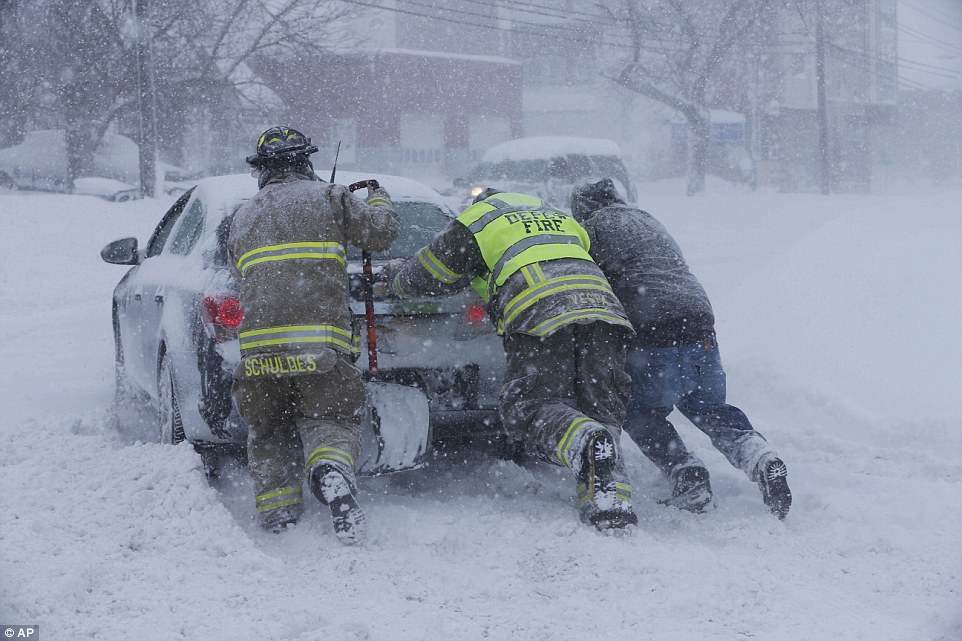 Firefighters worked to free a car stuck in the snow in Depew, New York, which was also socked on Tuesday