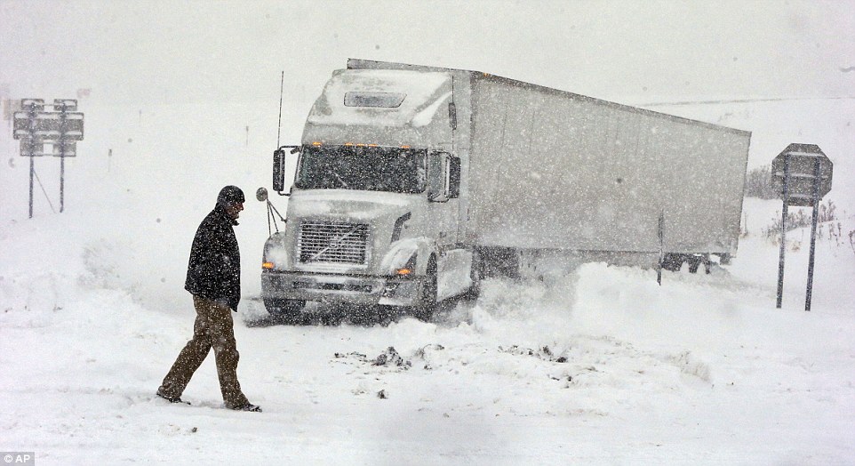 Stuck: A truck driver in Boston, New York, stands outside his stranded rig, which got stuck on an exit ramp