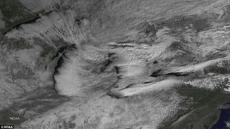 Whiteout: Snowy clouds can be seen swirling over the Great Lakes, center, and expanding into New York State and New England