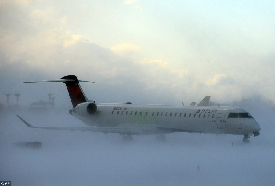 Frozen: Air travel was also hit by delays thanks to the snow - above is a Delta Airlines plan at Buffalo Greater International Airport