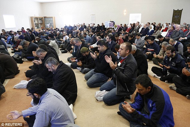 Men are seen praying for their slain brother, Abdul-Rahman Kassig, who was executed by ISIS in Syria