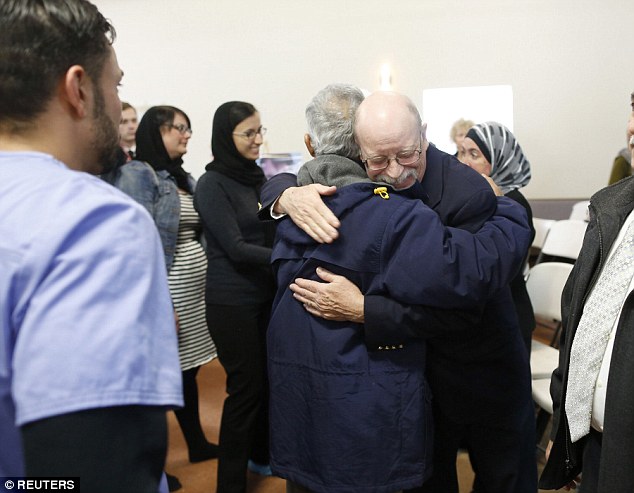 Ed Kassig is greeted by a mourner during the absentia prayer service for his son