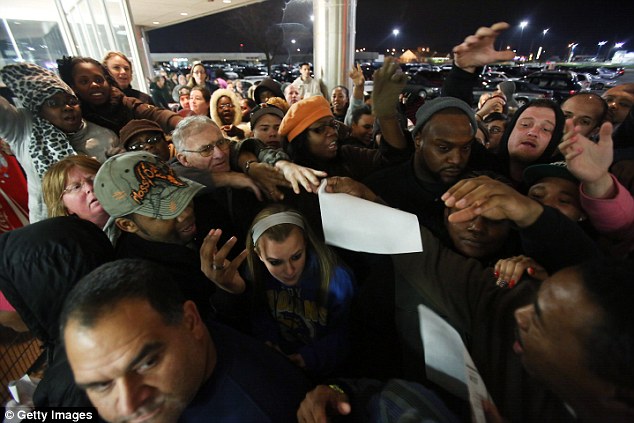 Chaos: It might not be worth it to wait in line outside a big box store this Black Friday. Many stores will be open on Thanksgiving Day itself and are already slashing prices. Above, shoppers grapple for Black Friday advertisements outside a Kmart in Griffith, Indiana last year on November 22 