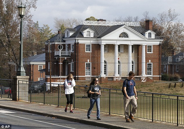University of Virginia students walk to campus past the Phi Kappa Psi fraternity house at the University of Virginia.  The university has suspended activities at all campus fraternal organizations amid an investigation into a published report in which a student described being sexually assaulted by seven men in 2012 at the Phi Kappa Psi house