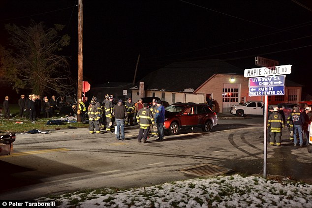 Emergency: Police gather near the scene and appear to stand near the SUV that was involved in the crash 