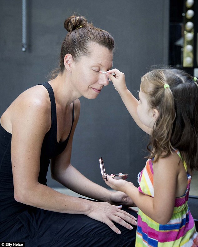Rather than attempting to conceal perceived flaws, the children instead use the face - and in many cases the hands and arms too- as a canvas to be celebrated with bold colours. Here Abby Howell applies mascara to her mother Kerri Madsen