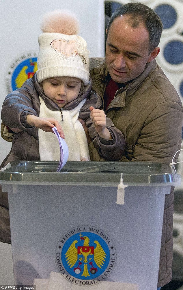 A child casts her father's ballot at a polling station in Chisinau during yesterday's election 