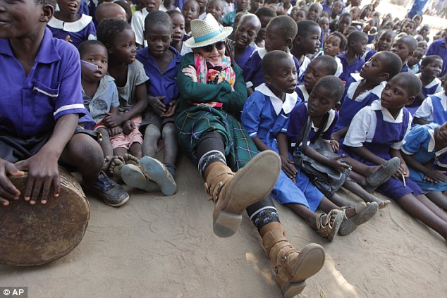 Looking to adopt again? Madonna, centre, poses for a  picture with children in Kasungu, about 150 kilometers north of the Malawian capital Lilongwe 