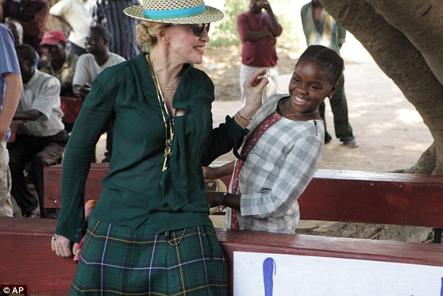 Forgiven: Madonna had her 'VVIP' status restored by Malawi after being called 'arrogant' by the country's president in April last year. This time she played with  her daughter Mercy as the girl's family issued a plea to see her