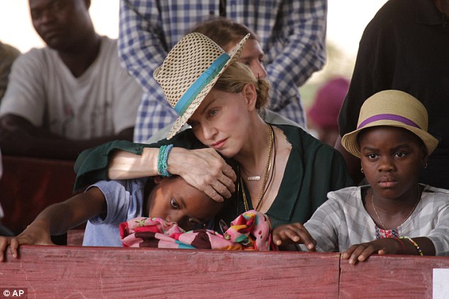 Madonna, pictured with children Mercy James and David Banda, both nine, who she adopted from the African nation, has already helped to fund 10 schools in the country and her charitable efforts are not yet finished