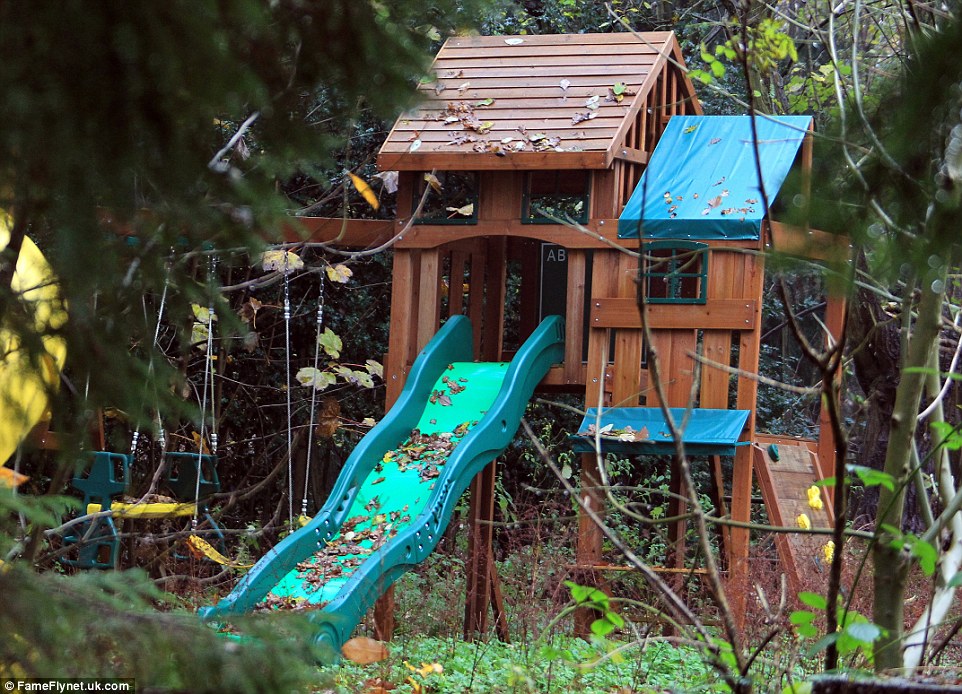 Abandoned slides and swings are covered in the autumnal leaves.  The drive leading to the front door is also covered in leaves and the weeds stand tall in the garden