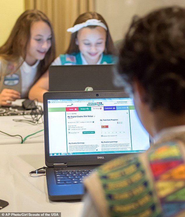 Screen time: Girl Scouts are seen learning how to sell cookies on the organization's website using laptops