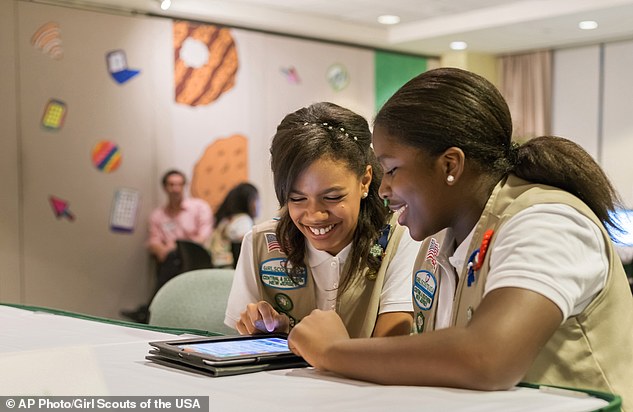 Going digital: Girl Scouts Bria (left) and Shirell (right) practice selling cookies on a tablet now that the organization has allowed online sales 