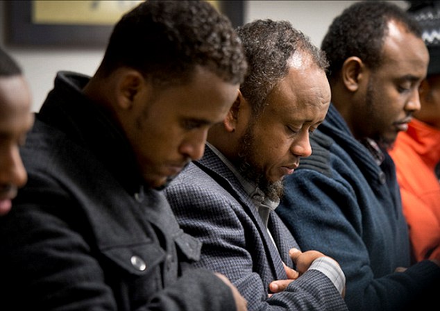 Bowed in prayer: Somali men gather to pray the day after the 15-year-old was allegedly struck by Aden