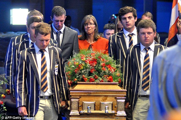 Pierre Korkie's tearful widow Yolande follows the flower-laden casket, which was carried by uniformed students at the South African school where he had taught
