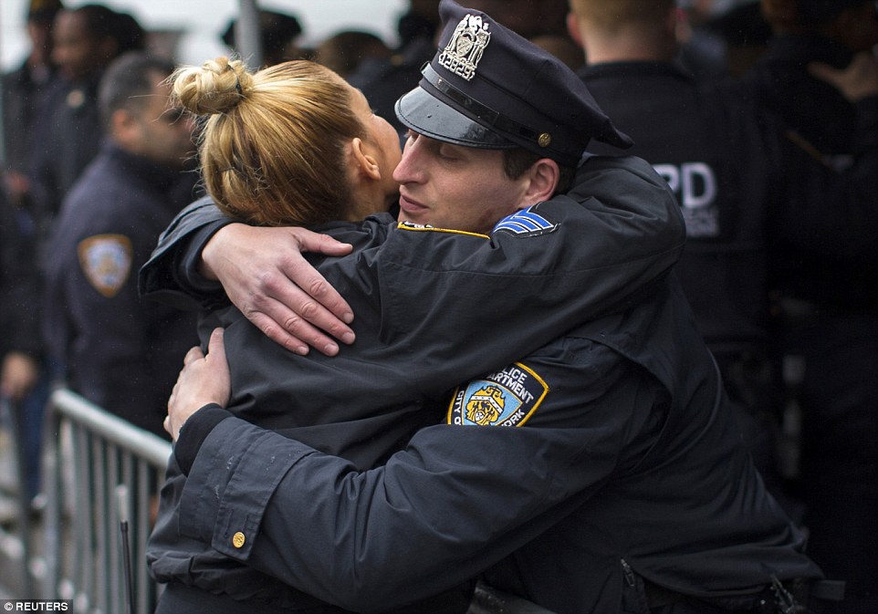 Unity: Cops embraced one another while members of the public gathered to express their feelings at the Saturday double murder