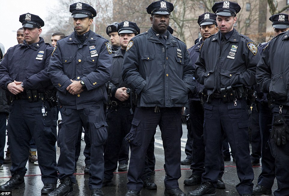 Paying respects: At the memorial in Brooklyn, officers bowed their heads and paused as well