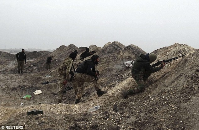 Rebel fighters take up positions behind sand barricades as the war in Syria drags on in the wake of hundreds of atrocities prepetrated by ISIS militants