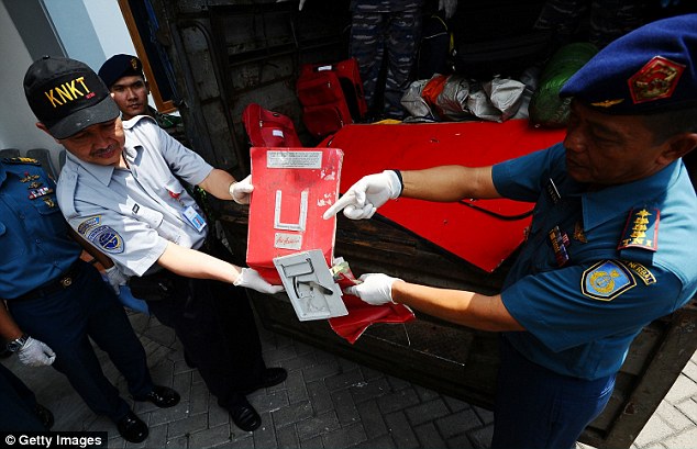 Indonesia National Transportation Safety Committee officers show parts of the AirAsia aircraft
