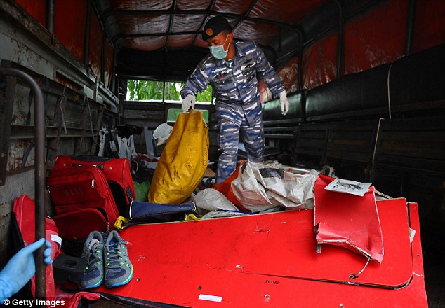  Indonesian Navy personnel soft through a variety of personal items and wreckage from AirAsia Flight QZ8501