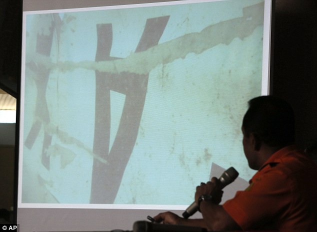 Chief of Indonesia's search and rescue agency Bambang Soelitsyo shows an underwater photo of a part of the wreckage of AirAsia Flight 8501
