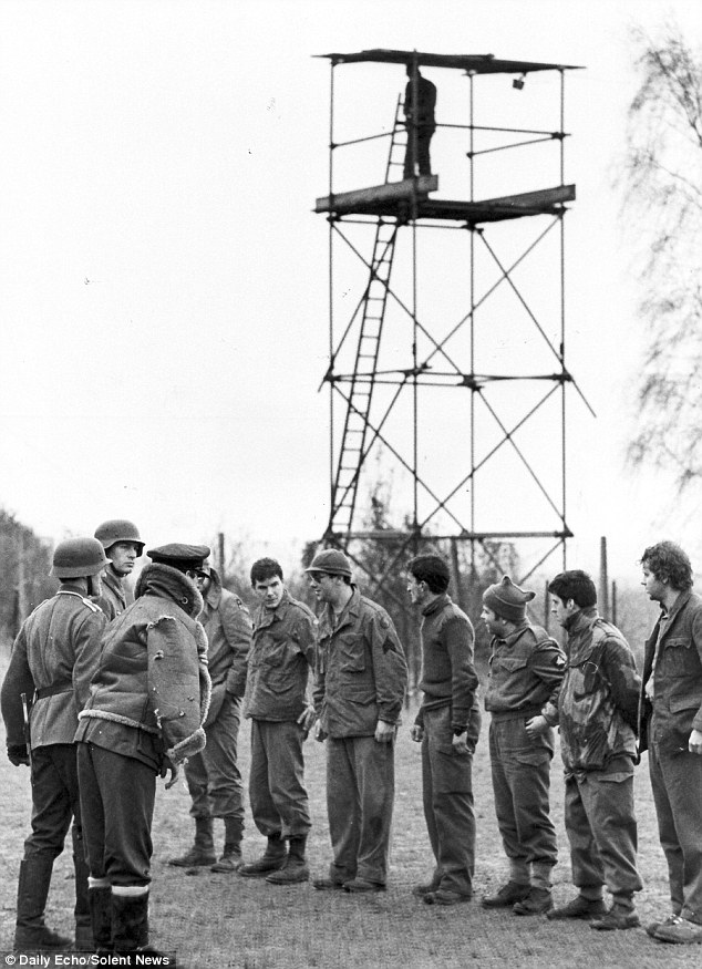 Watched over by guards in full SS uniforms, held at gunpoint and ordered to line up for inspection (pictured) these incredible black and white photographs look like they were taken of German prisoners of war during the Second World War