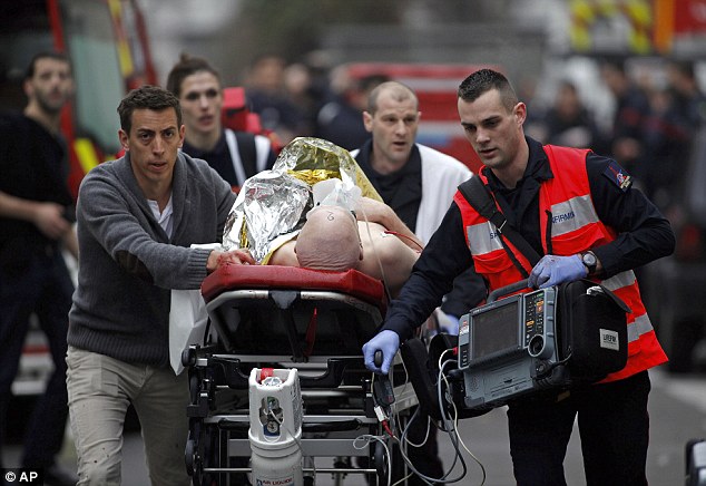 An injured person is evacuated outside the French satirical newspaper Charlie Hebdo's office