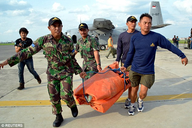 Navy personnel carry air balloons into a NC212 aircraft at Juanda airbase