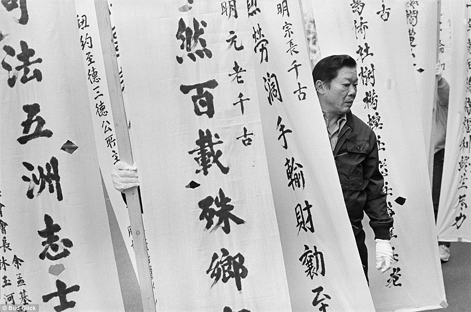 A man carries signs into a funeral in 1982