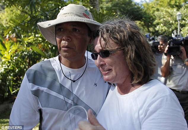 Distraught: A tourist who was on the cruise when the boat began to sink cries as she holds a cup