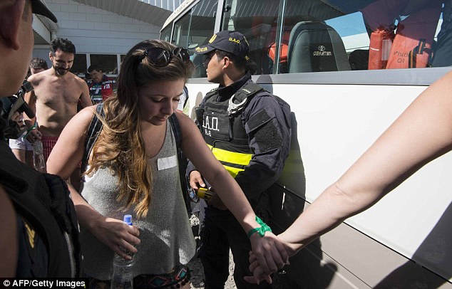 Guiding: A woman holds another survivor's hand as she steps onto the bus. Authorities are still unsure as to what caused the deadly accident 