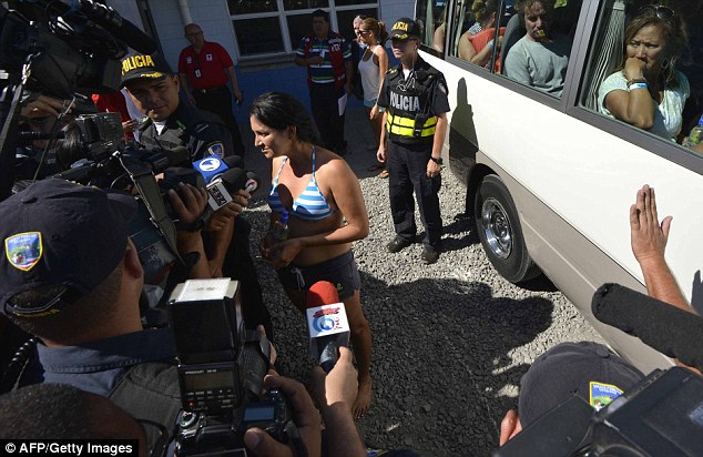 Reaction: One of the survivors speaks to the waiting media as she prepares to board a bus to her hotel 