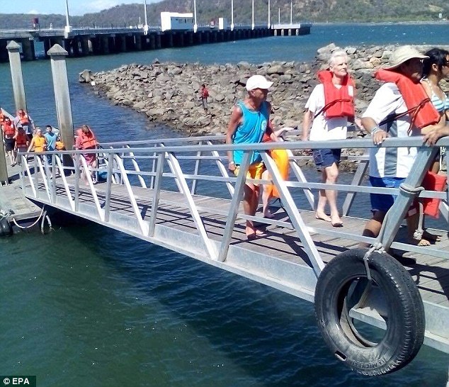 On land: A group of tourists walk from rescue boats before being moved by authorities to their hotels