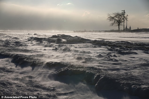 Wind blows snow off the North Avenue Beach along the Lake Michigan shore, Wednesday, January 7, 2015, in Chicago 