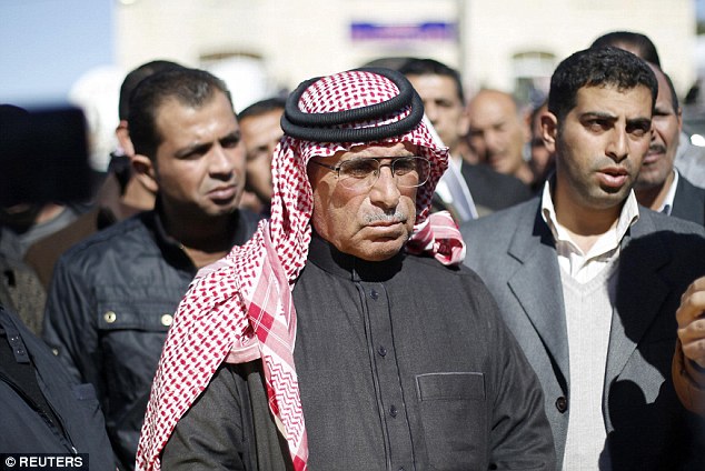 Inconsolable: Saif al-Kasasbeh (centre), the father of Jordanian pilot Moaz al-Kasasbeh, is seen at the headquarters of the family's tribe in the city of Karak today as he mourns the loss of his son