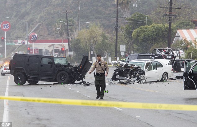 Jenner smash: A Los Angeles County Sheriff's deputy investigates the scene of a crash involving three vehicles in Malibu, California on February 7. Kim Kardashian's stepfather Bruce Jenner was in one of the cars involved